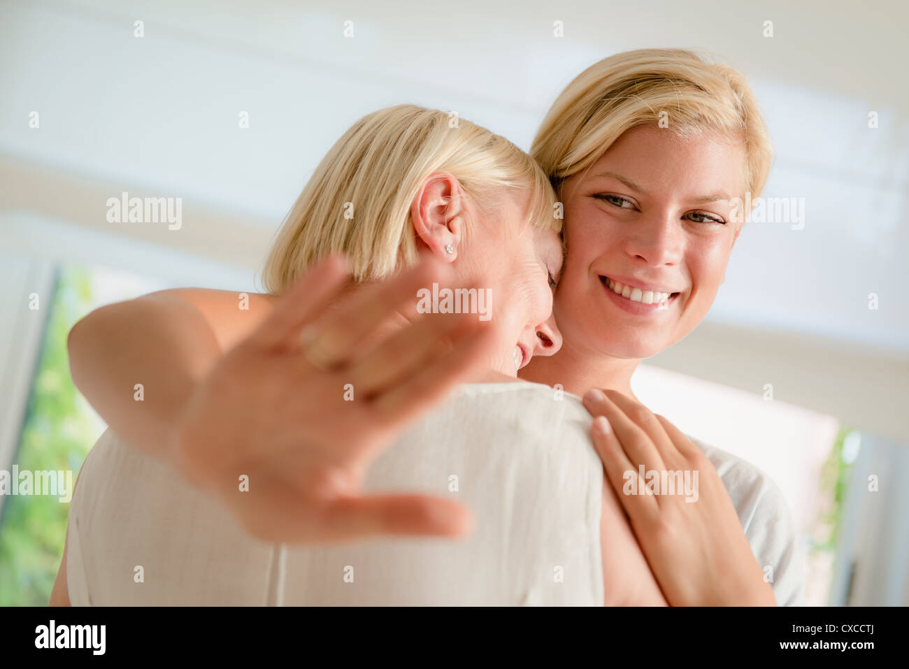 L'amour de la famille et de gens heureux, jeune femme montrant bague de fiançailles de sa mère et s'étreindre Banque D'Images