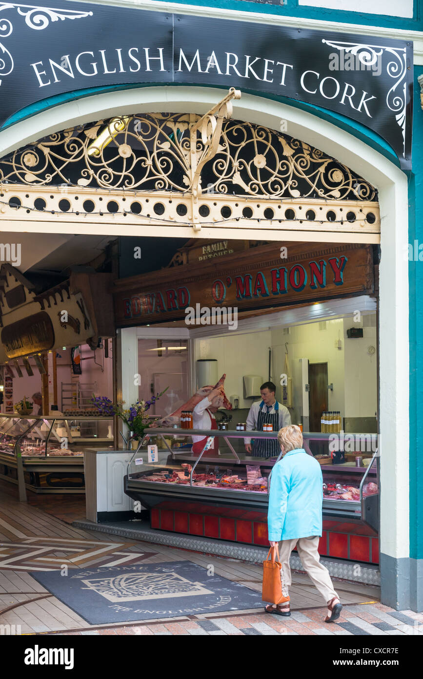 Un boucher avec son ensemble par-dessus son épaule le marché anglais, la ville de Cork, République d'Irlande. Banque D'Images