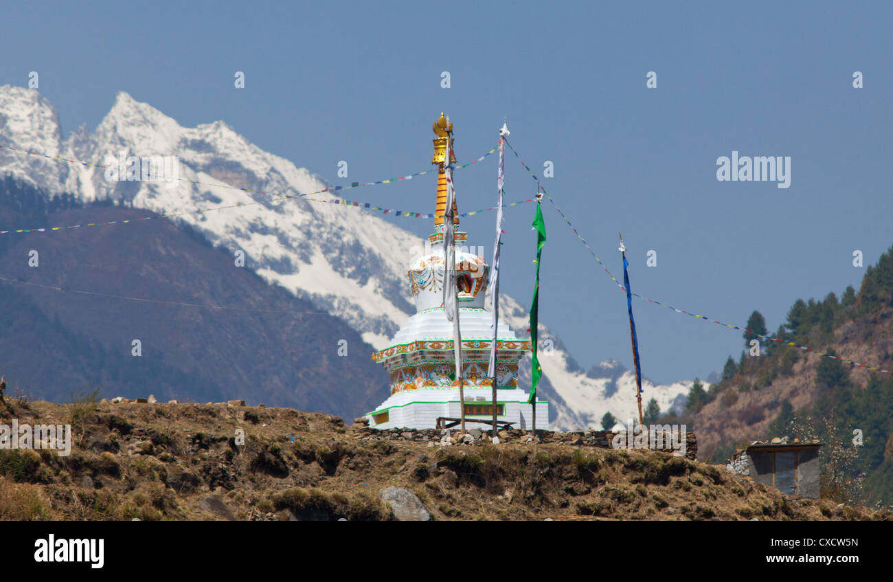 Avec un stupa bouddhiste de montagnes enneigées au loin, au Népal Banque D'Images