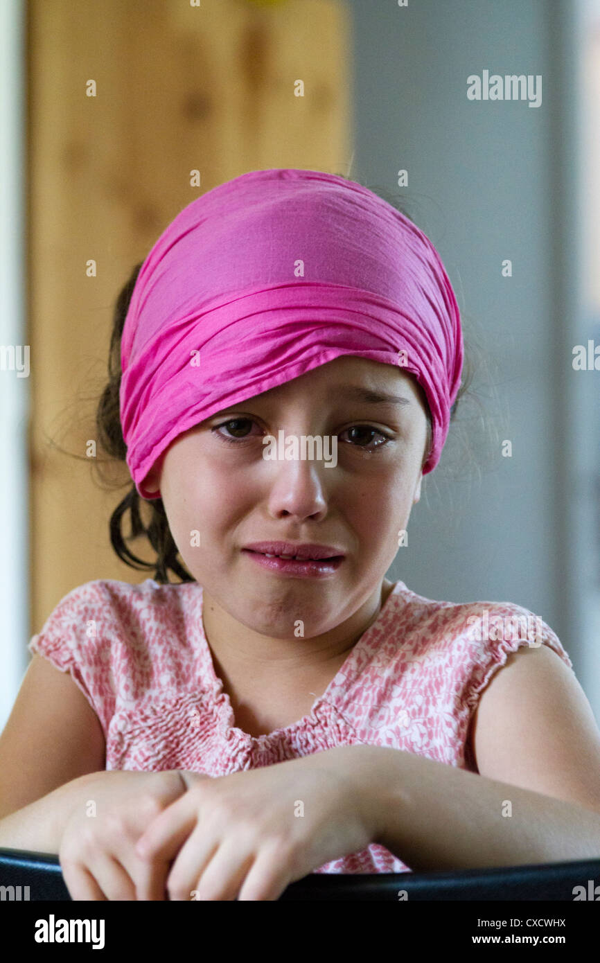 Une fillette de 7 ans avec un foulard de pleurer Photo Stock - Alamy