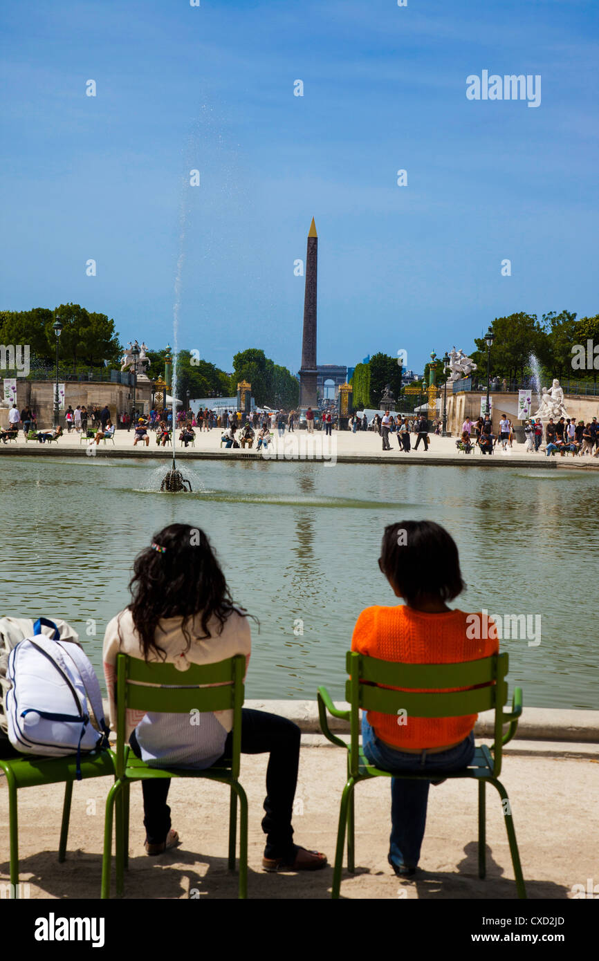 Deux touristes se détendre à côté d'une pièce d'eau dans Jardin des Tulleries à la direction Place de la Concorde à Paris France Banque D'Images