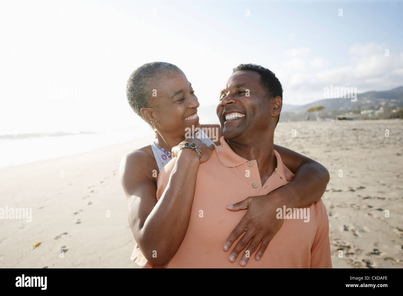 Black couple hugging on beach Banque D'Images