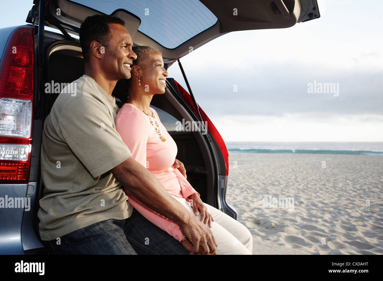 Black couple sitting on bicorps profitant de la plage Banque D'Images