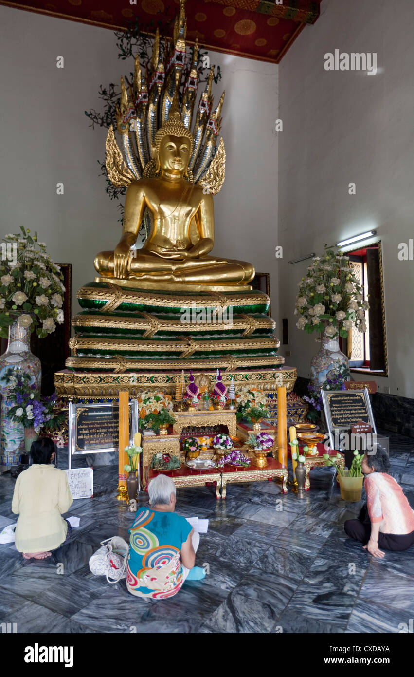 Les gens priant et assis sous la statue de Bouddha Chiang Mai Thaïlande Banque D'Images