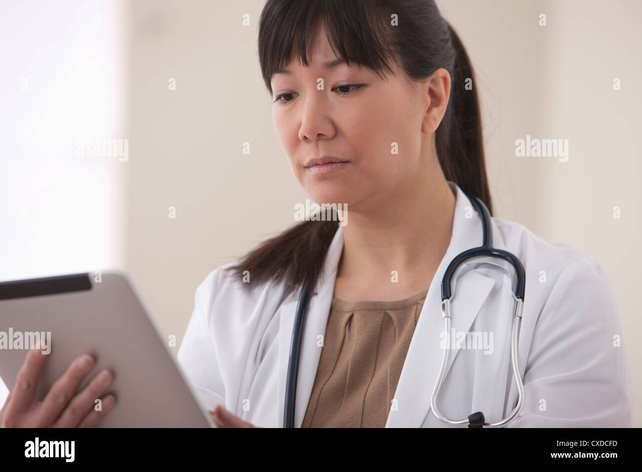 Médecin asiatique using digital tablet Banque D'Images