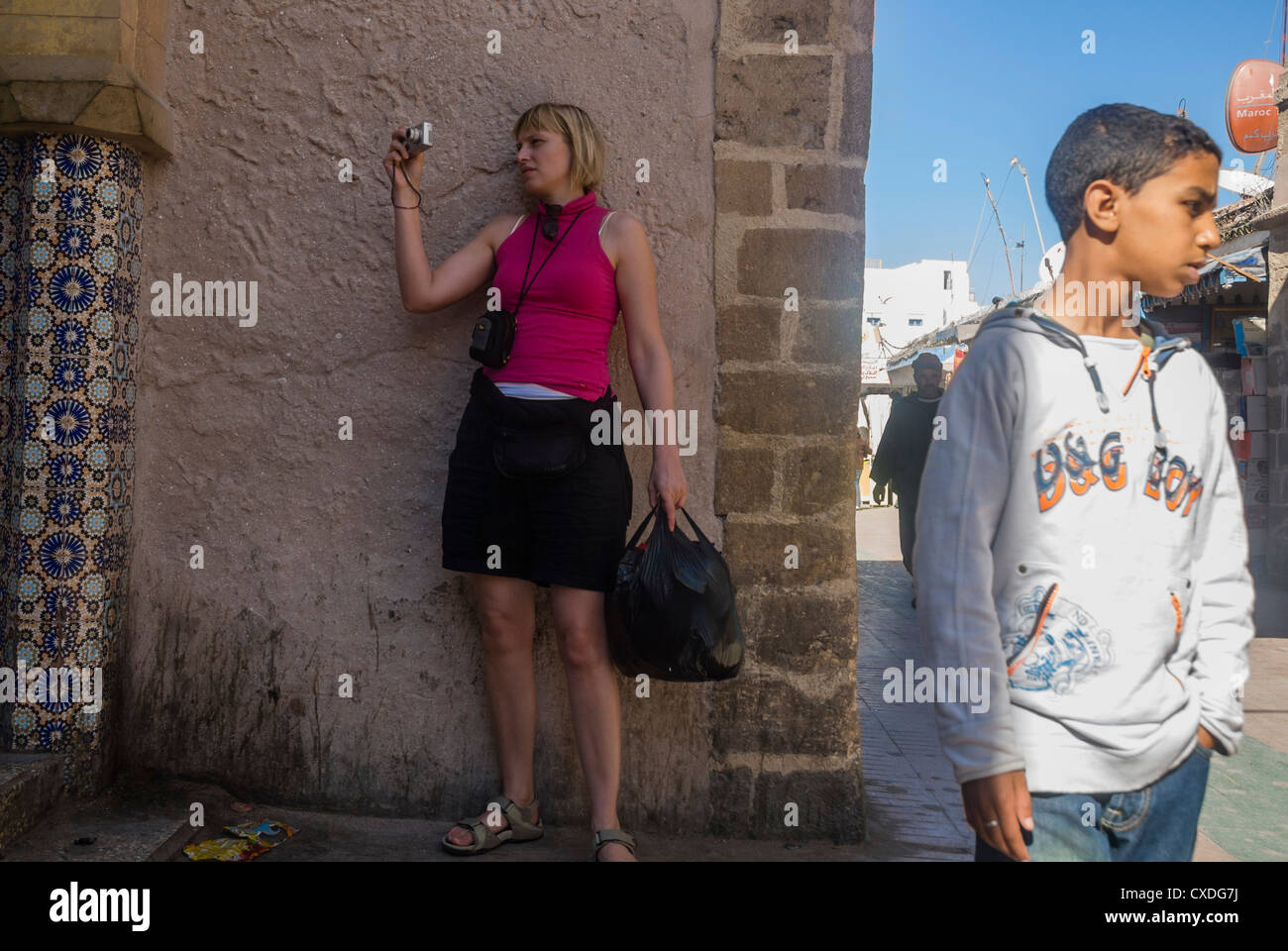 Une femme à Essaouira en photographiant avec un appareil photo numérique compact avec un jeune écolier Banque D'Images