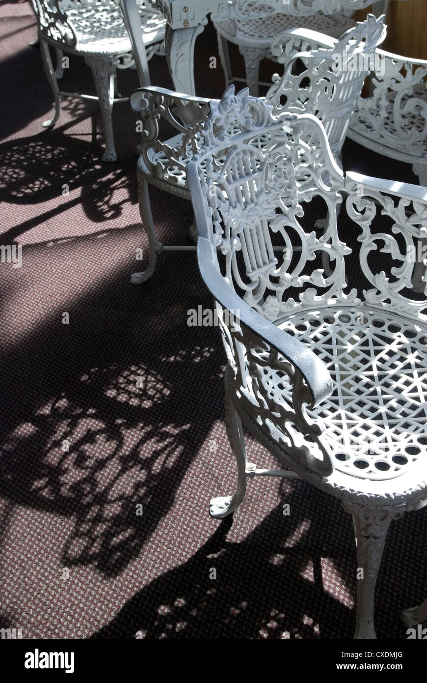 Peint en blanc antique de chaises en fer forgé s'asseoir dans la lumière du soleil sur la roue à aubes riverboat. Banque D'Images