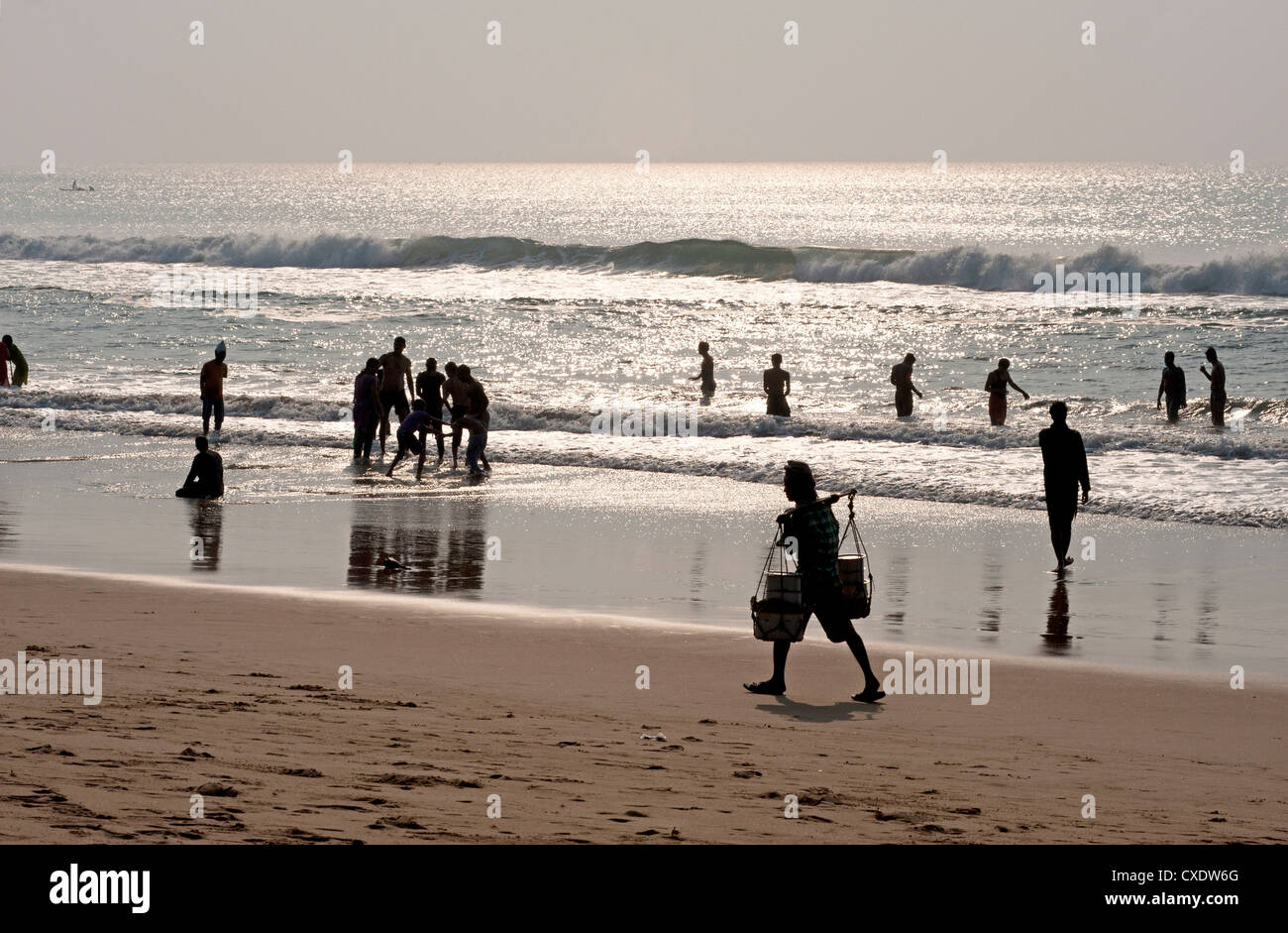 Puri Beach sur la baie de Bengaln détente familles et pagaie, vendeur de plage par marche en fin d'après-midi, Puri, Orissa Banque D'Images