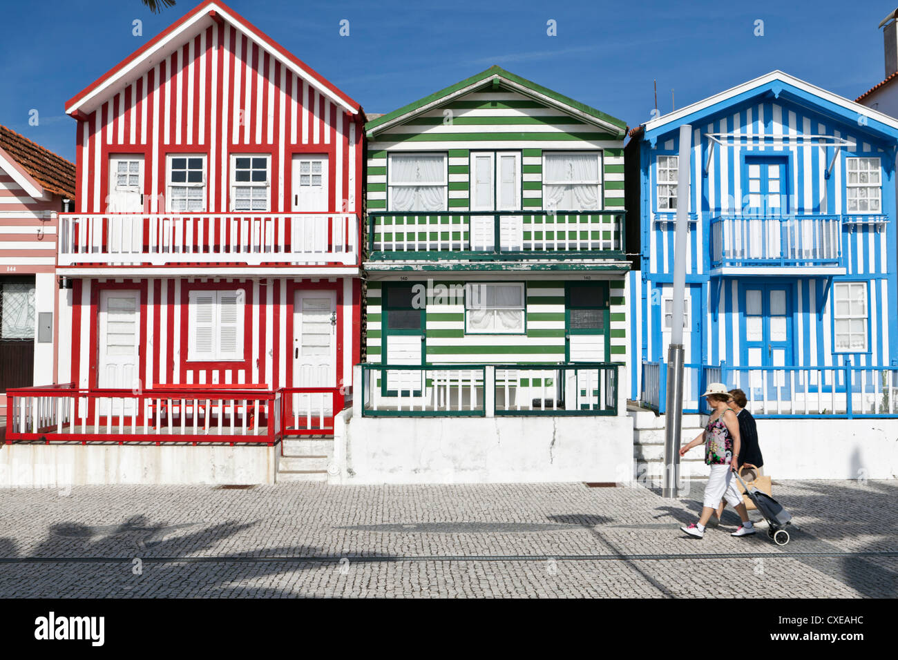 Dames âgées à pied par des maisons de plage peint au Costa Nova, Beira Litoral, Portugal Banque D'Images