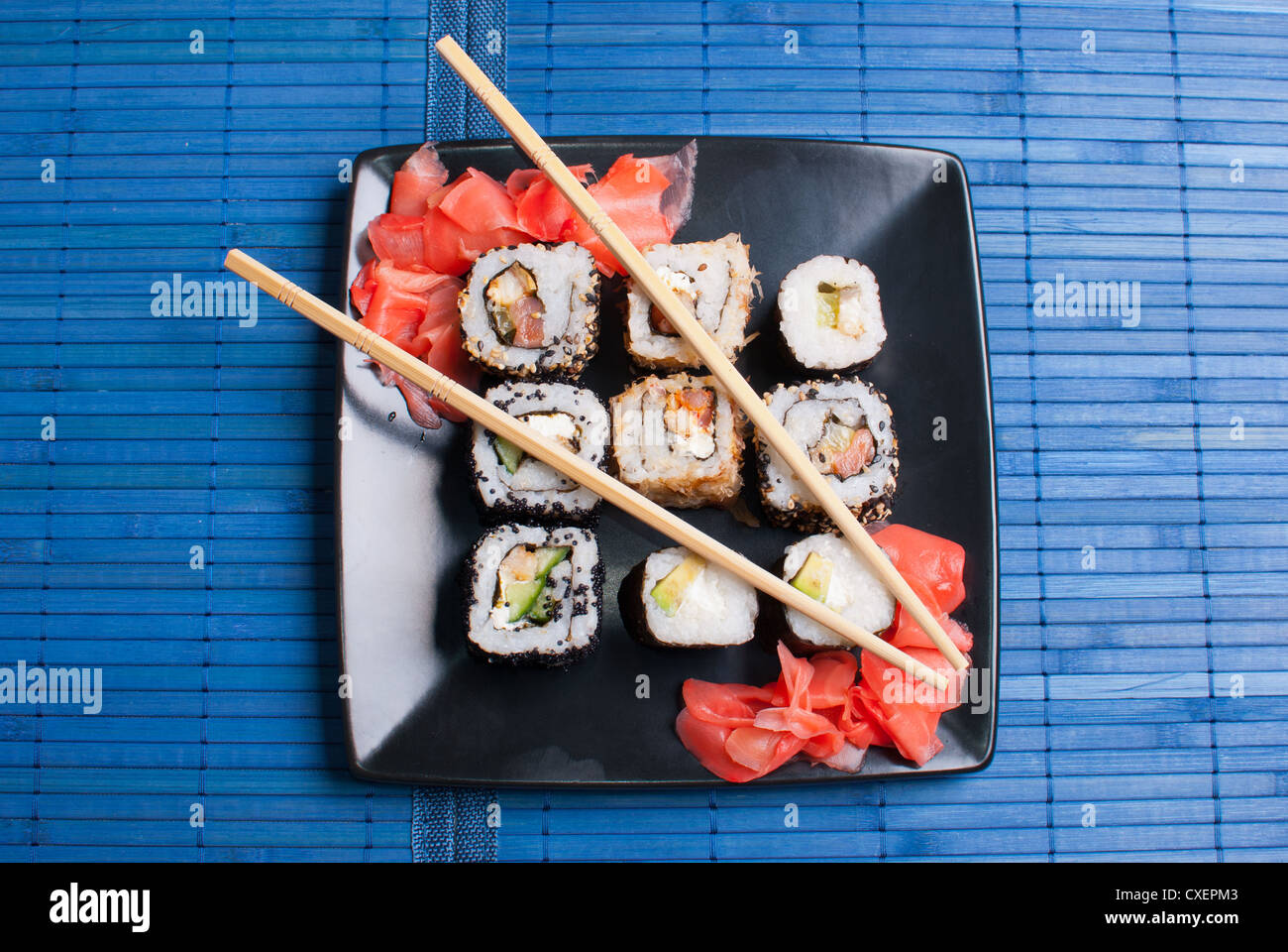Sushi sur une plaque noire sur la table. Banque D'Images