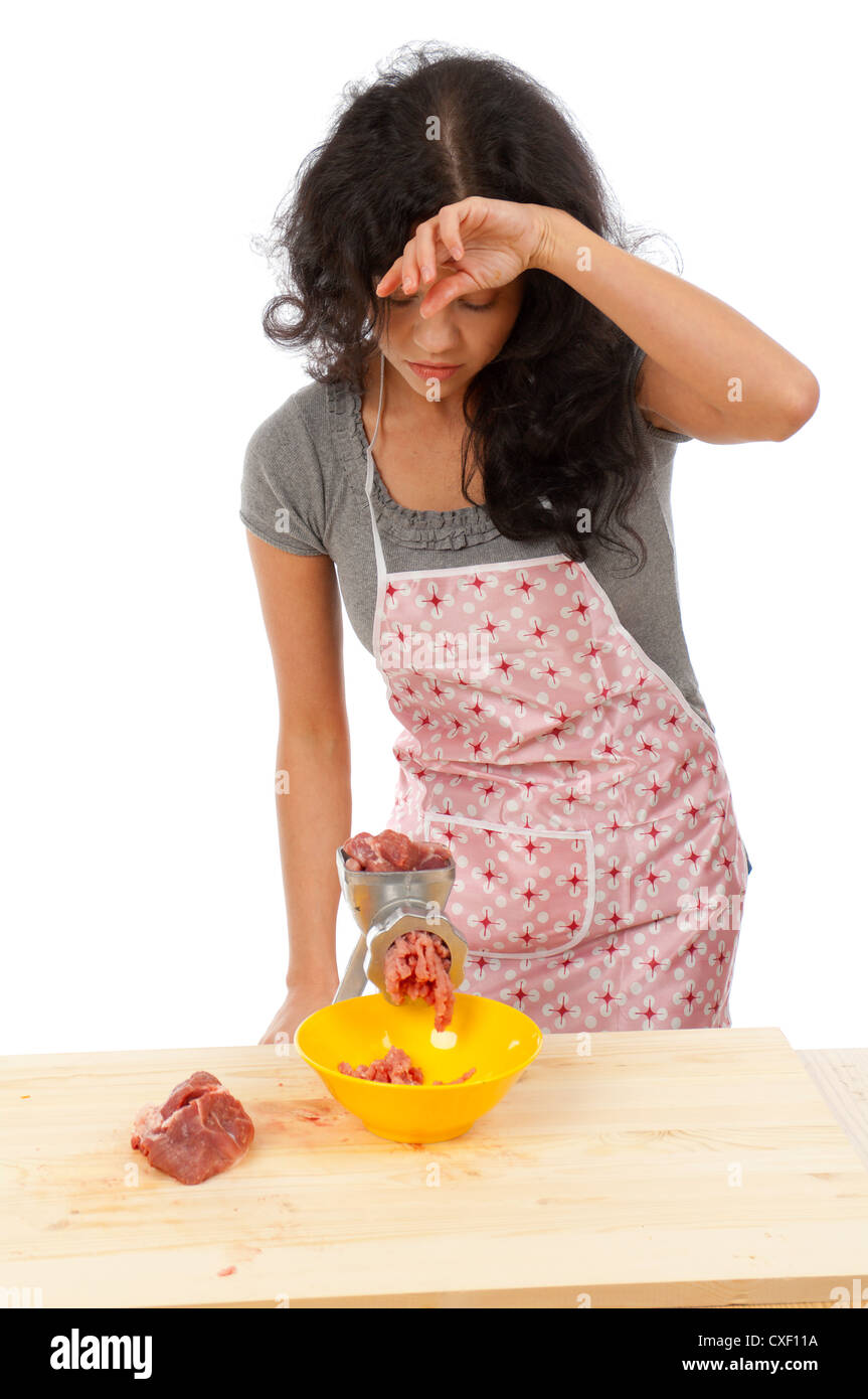 Beautiful housewife couper la viande Banque D'Images