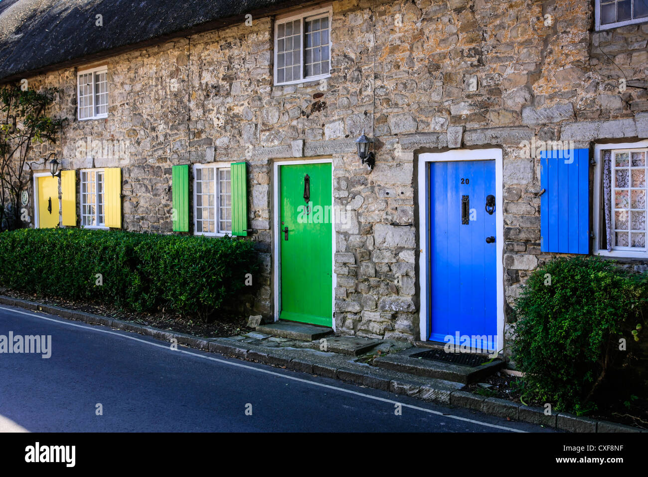 Jaune Vert et Bleu portes et volets sur une rangée de cottages dans le Dorset Banque D'Images