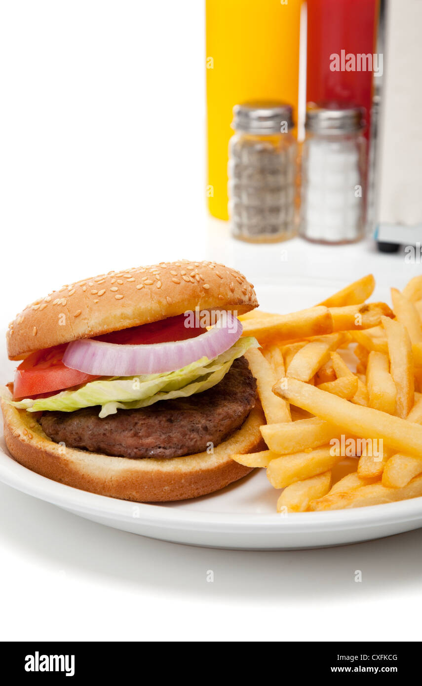 Hamburger frites et repas avec salières et poivrières, moutarde, ketchup et porte-serviettes Banque D'Images