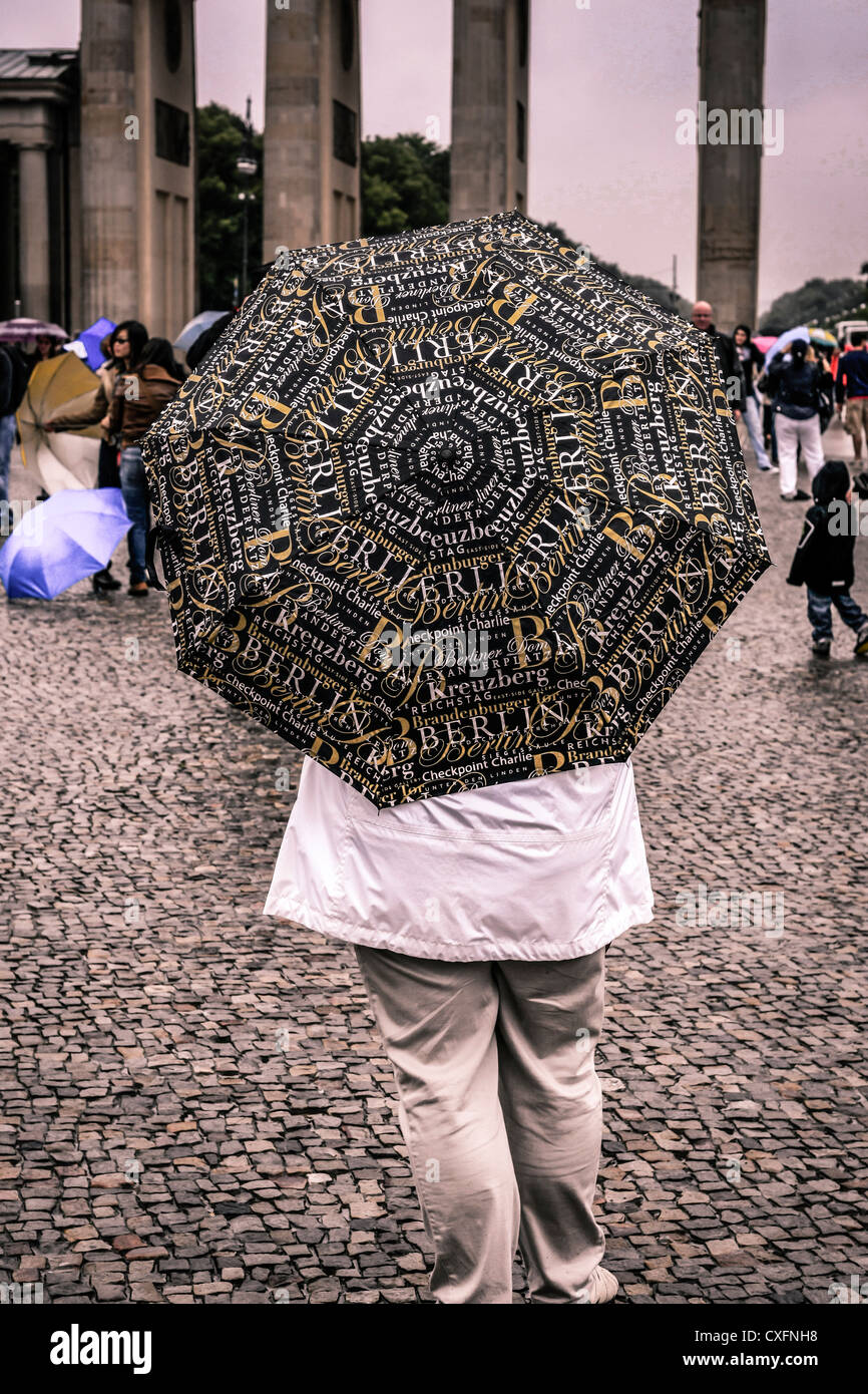 Femme debout avec un souvenir parapluie Berlin près de la porte de Brandebourg Banque D'Images