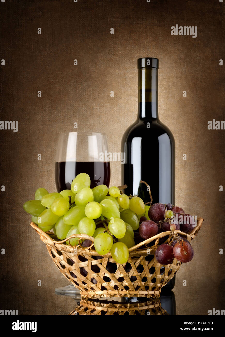 Bouteille de vin rouge et les raisins sur une toile de fond Banque D'Images