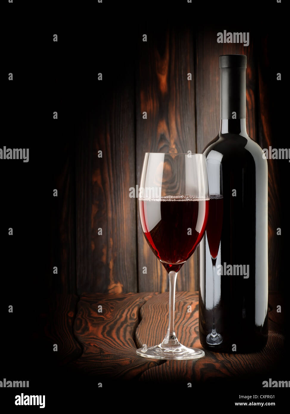 Vin rouge avec un verre de vin sur fond de bois Banque D'Images