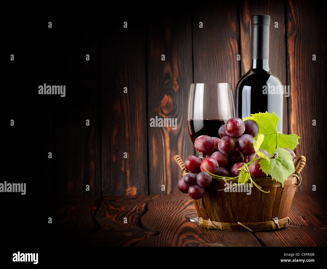 Vin rouge avec un verre de vin sur fond de bois Banque D'Images