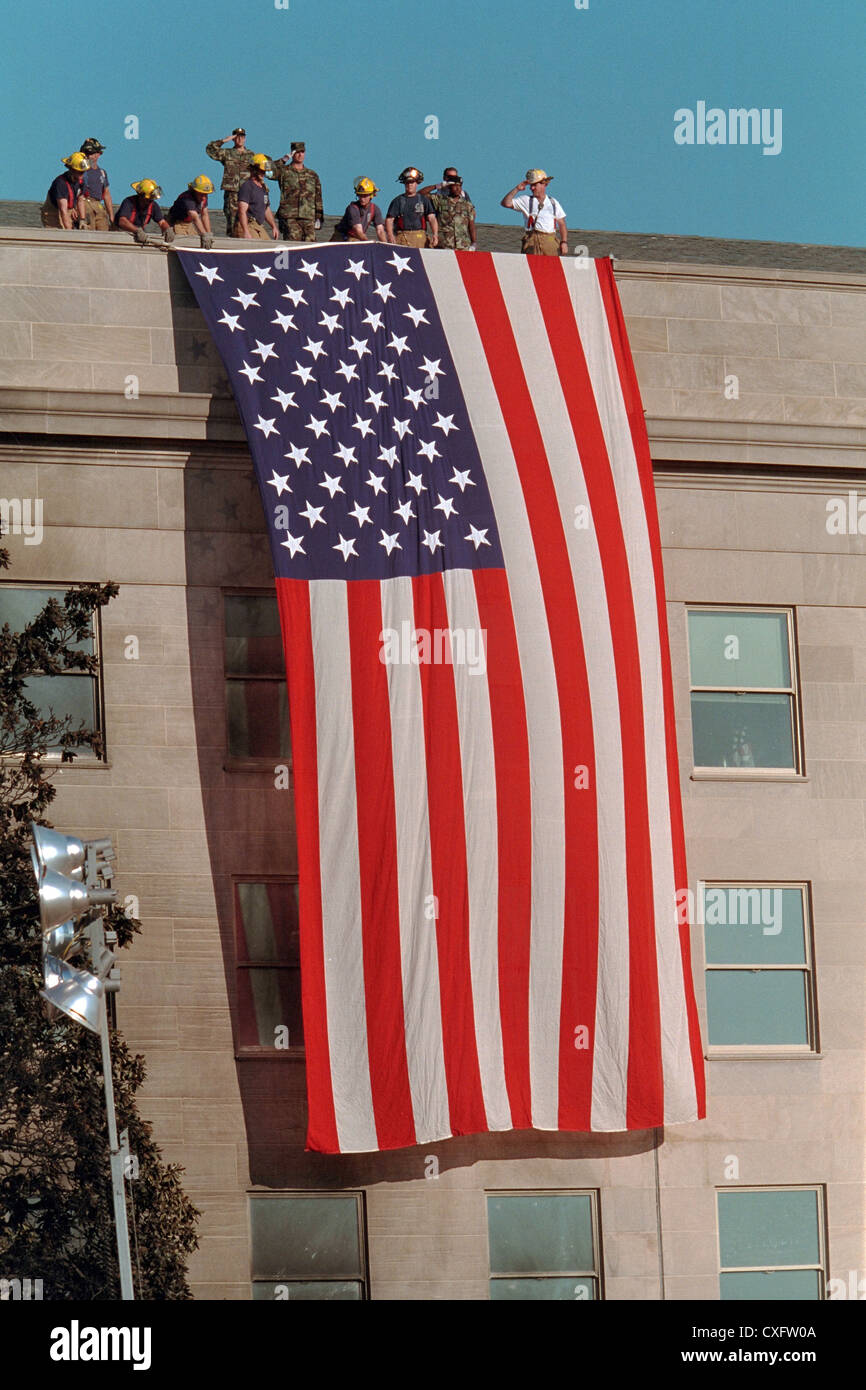 Le personnel d'urgence déployer le drapeau américain depuis le toit du Pentagone à la suite d'un attentat terroriste comme une valorisation des efforts continuent le 12 septembre 2001. Le 11 septembre, le vol 77 American Airlines détourné par des terroristes volent dans le bâtiment tuant les 64 passagers à bord et 125 personnes sur le terrain. Banque D'Images
