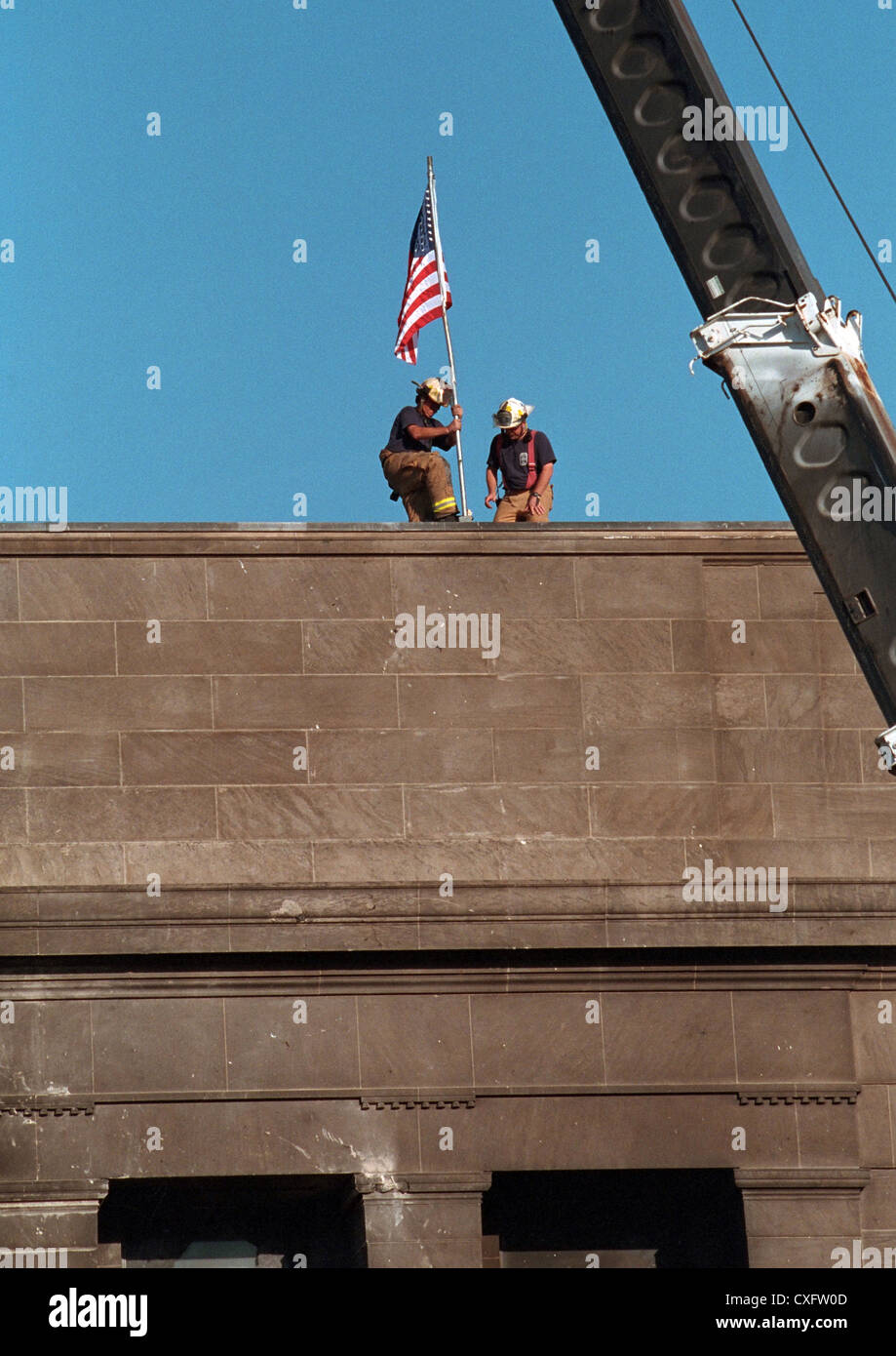Le personnel d'urgence déployer le drapeau américain depuis le toit du Pentagone à la suite d'un attentat terroriste comme une valorisation des efforts continuent le 12 septembre 2001. Le 11 septembre, le vol 77 American Airlines détourné par des terroristes volent dans le bâtiment tuant les 64 passagers à bord et 125 personnes sur le terrain. Banque D'Images