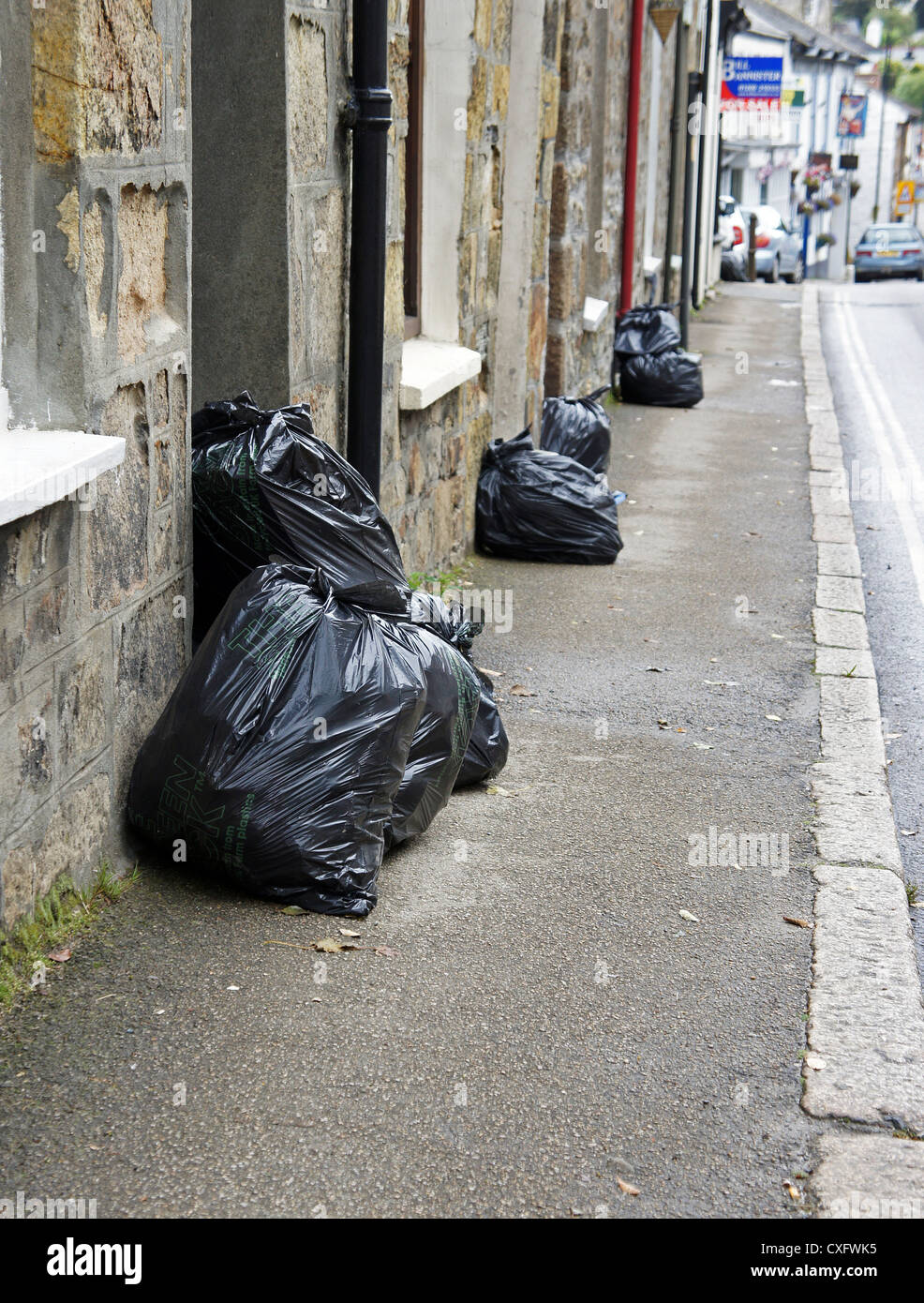 Sacs poubelle en plastique noir sur la porte des maisons sur la collecte des déchets jour au Royaume-Uni Banque D'Images