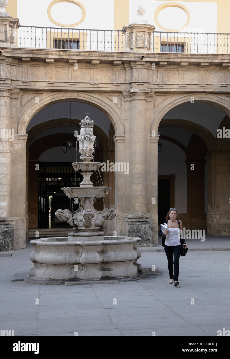 Jeune fille à la recherche d'étudiant comme marcher dans la cour intérieure de l'Université de Séville, bâtiment baroque autrefois l'usine de tabac Royal Banque D'Images