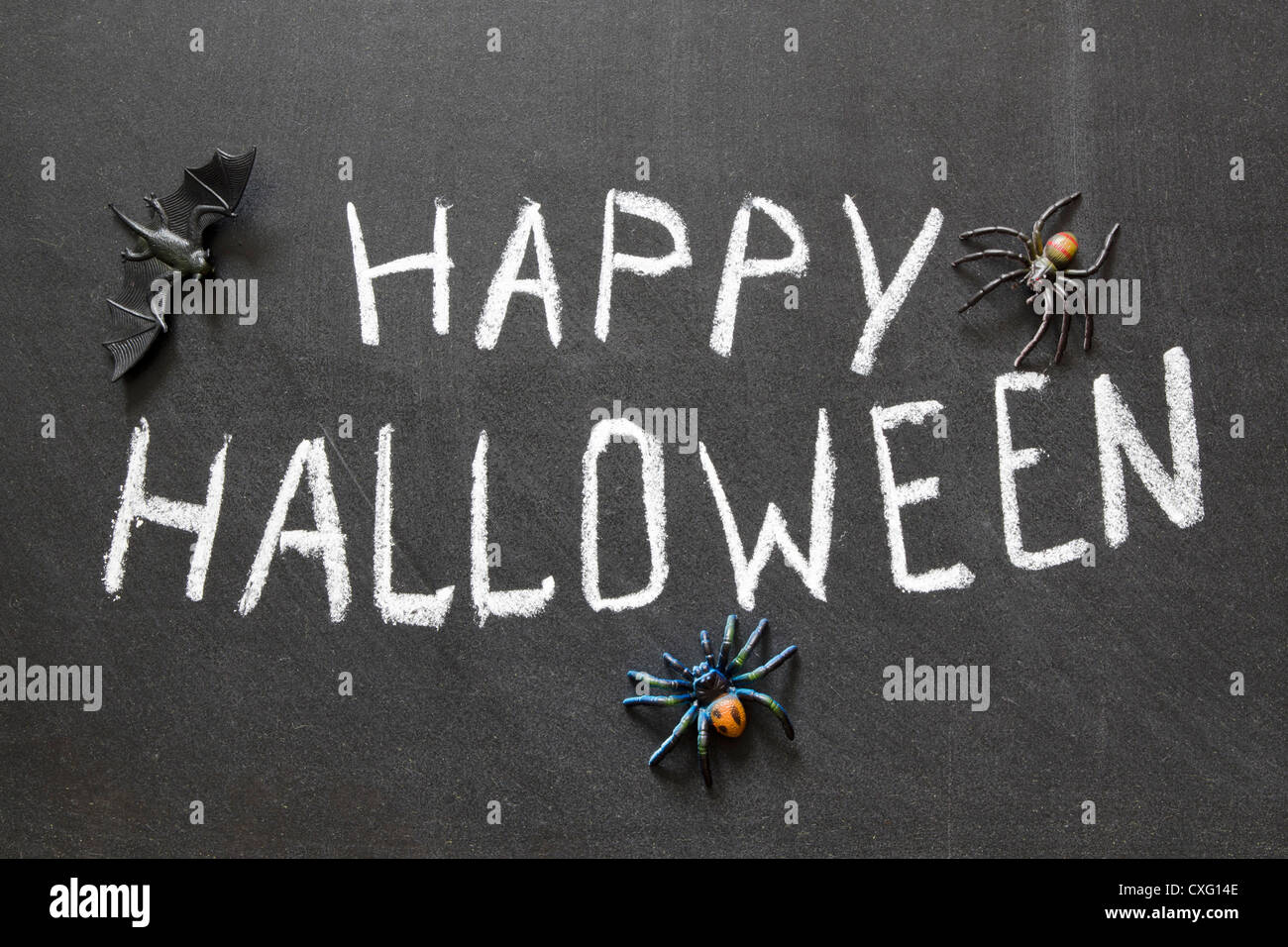 Happy Halloween message écrit à la main sur tableau noir avec les araignées autour de Banque D'Images