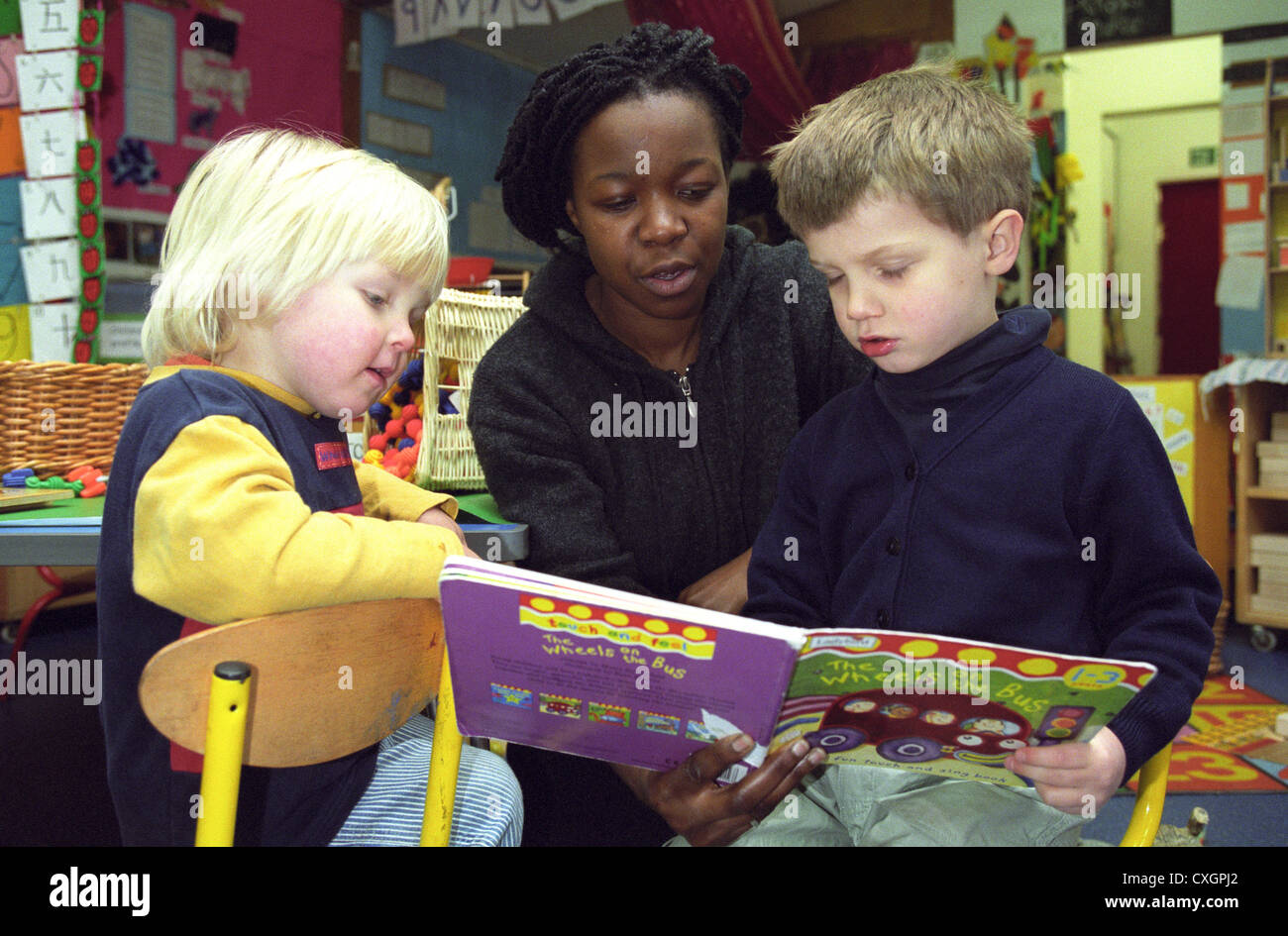 Les enfants qu'on leur fasse la lecture par enseignante en maternelle Banque D'Images