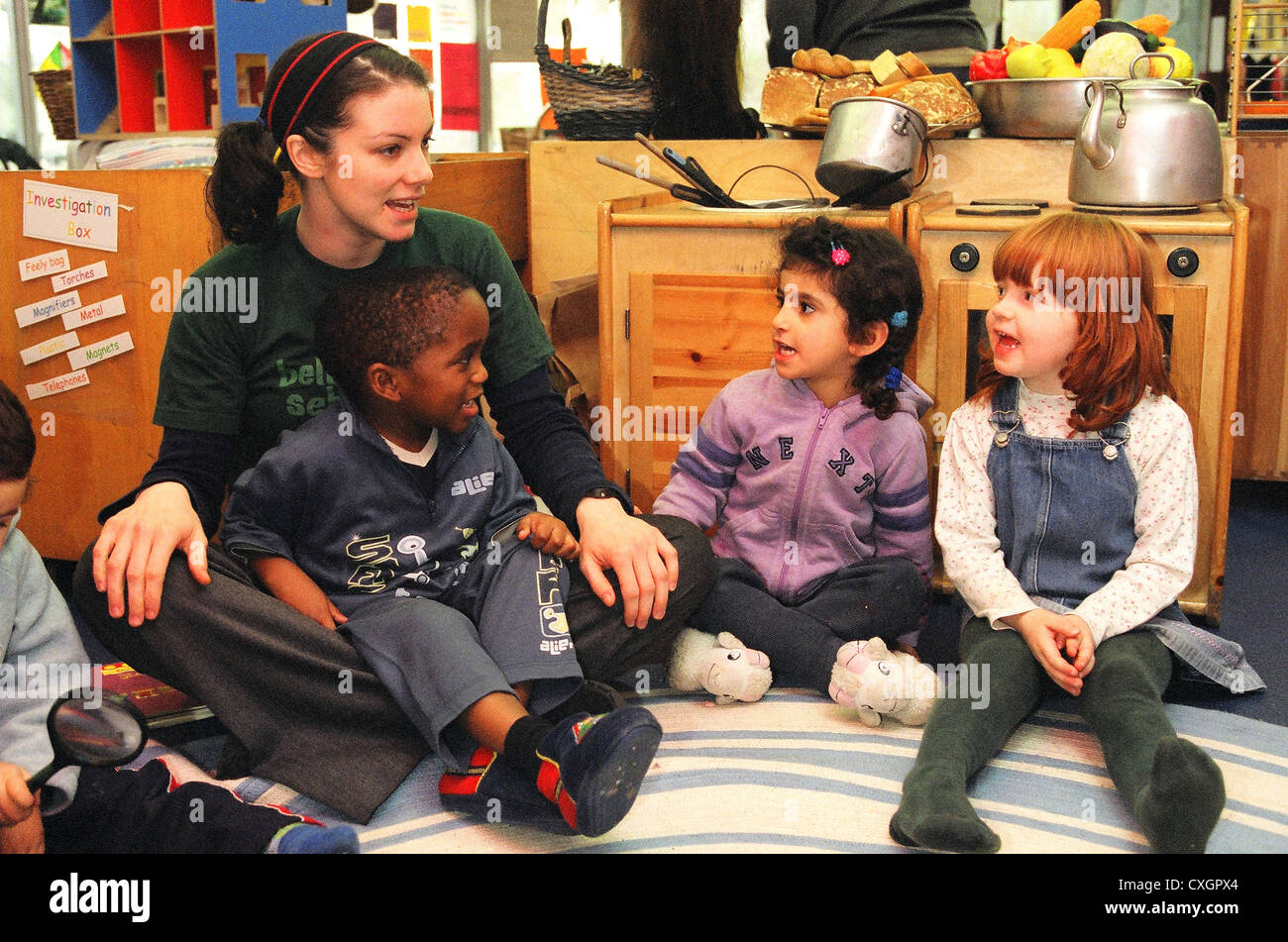 Lecture des enfants avec l'enseignant en école maternelle Banque D'Images