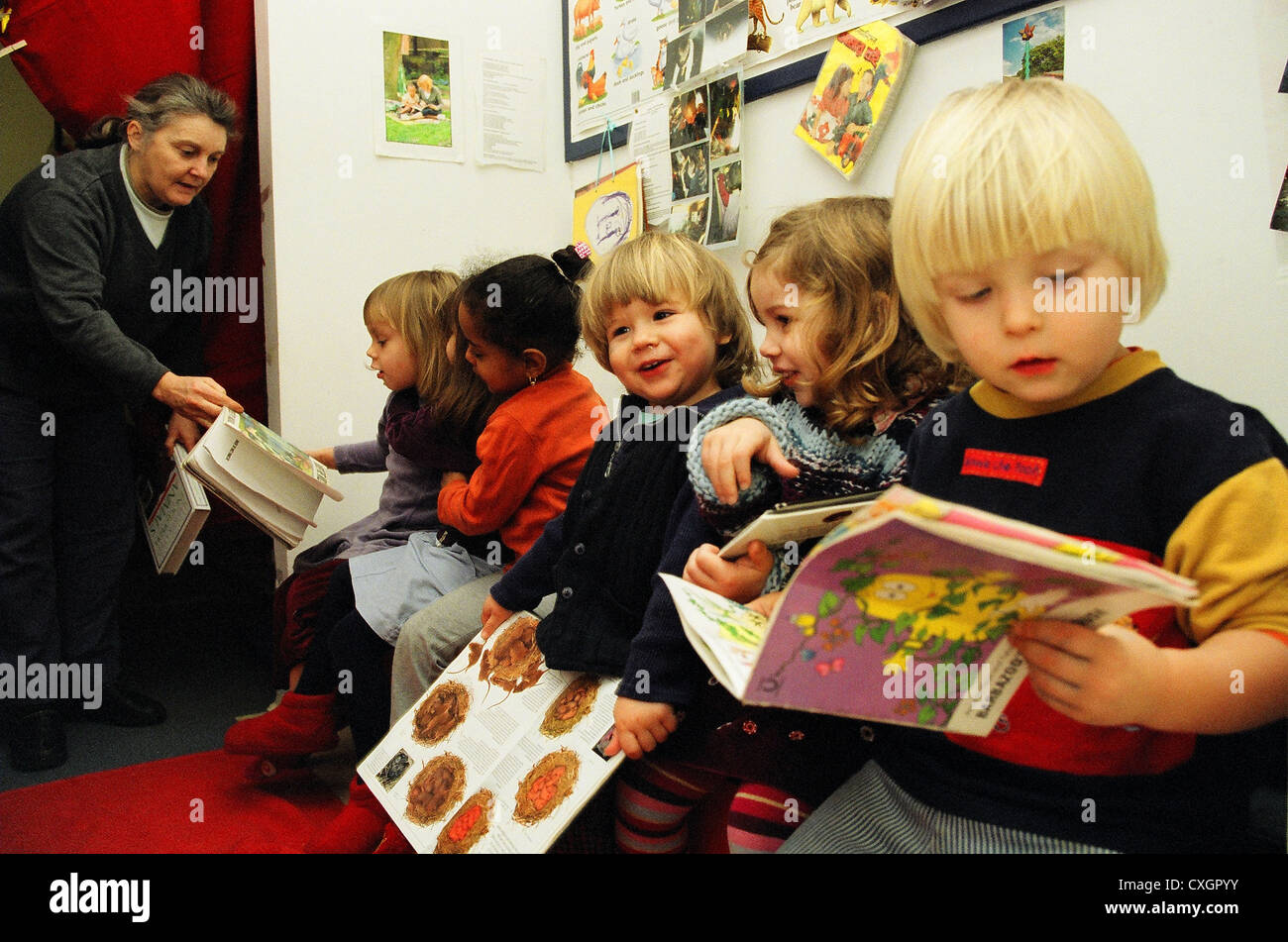 Lecture des enfants avec l'enseignant en école maternelle Banque D'Images