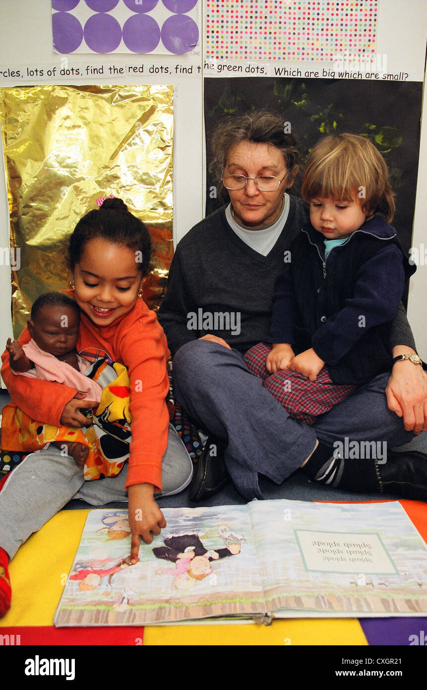 Lecture des enfants avec l'enseignant en école maternelle Banque D'Images