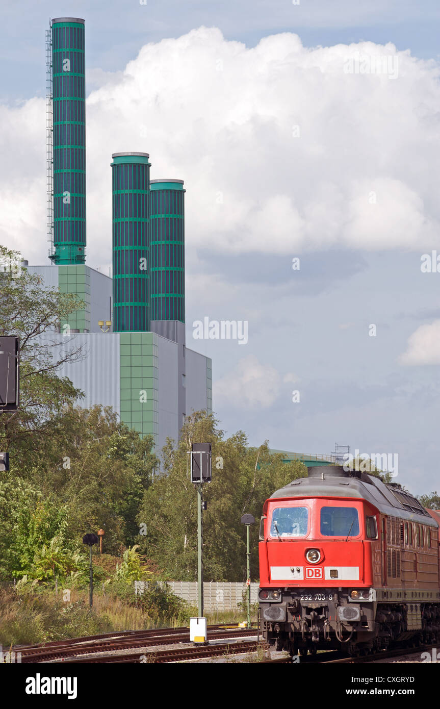 Train de marchandises et de la gare centrale au gaz avec panneaux solaires installés sur les cheminées d'usines Banque D'Images