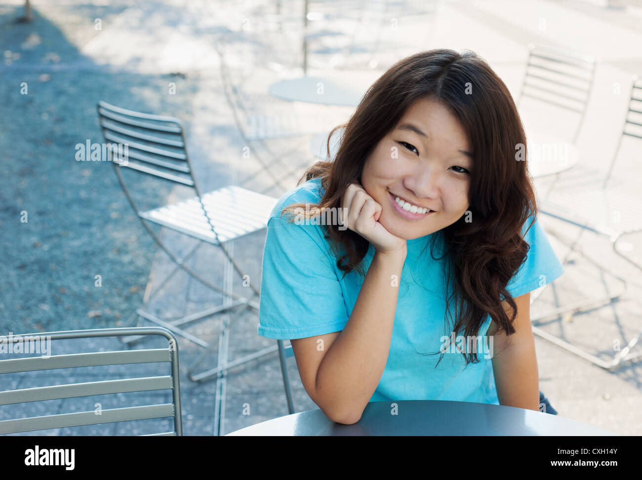 Les jeunes femmes à l'extérieur assis à une table smiling Banque D'Images