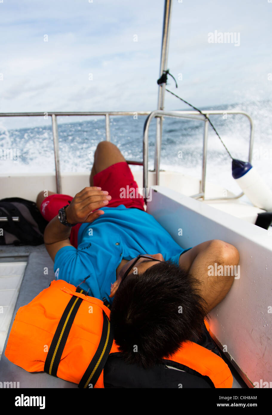 Divemaster relaxing on boat après une journée de plongée à Sipadan, Malaisie Bornéo Banque D'Images