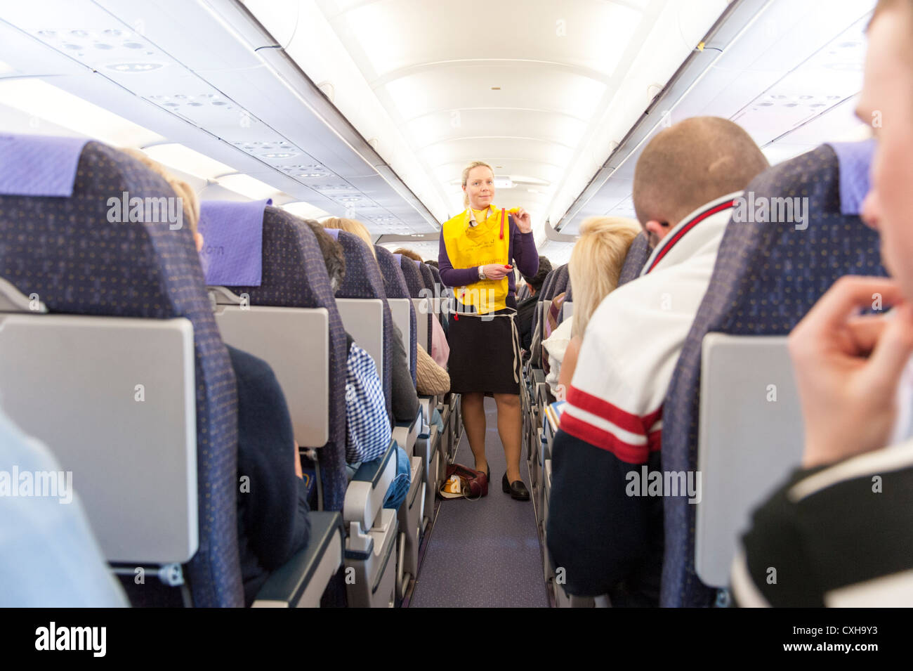 L'équipage de cabine de Monarch Airlines est en train de faire une démonstration de sécurité avant le vol, en Angleterre, au Royaume-Uni Banque D'Images