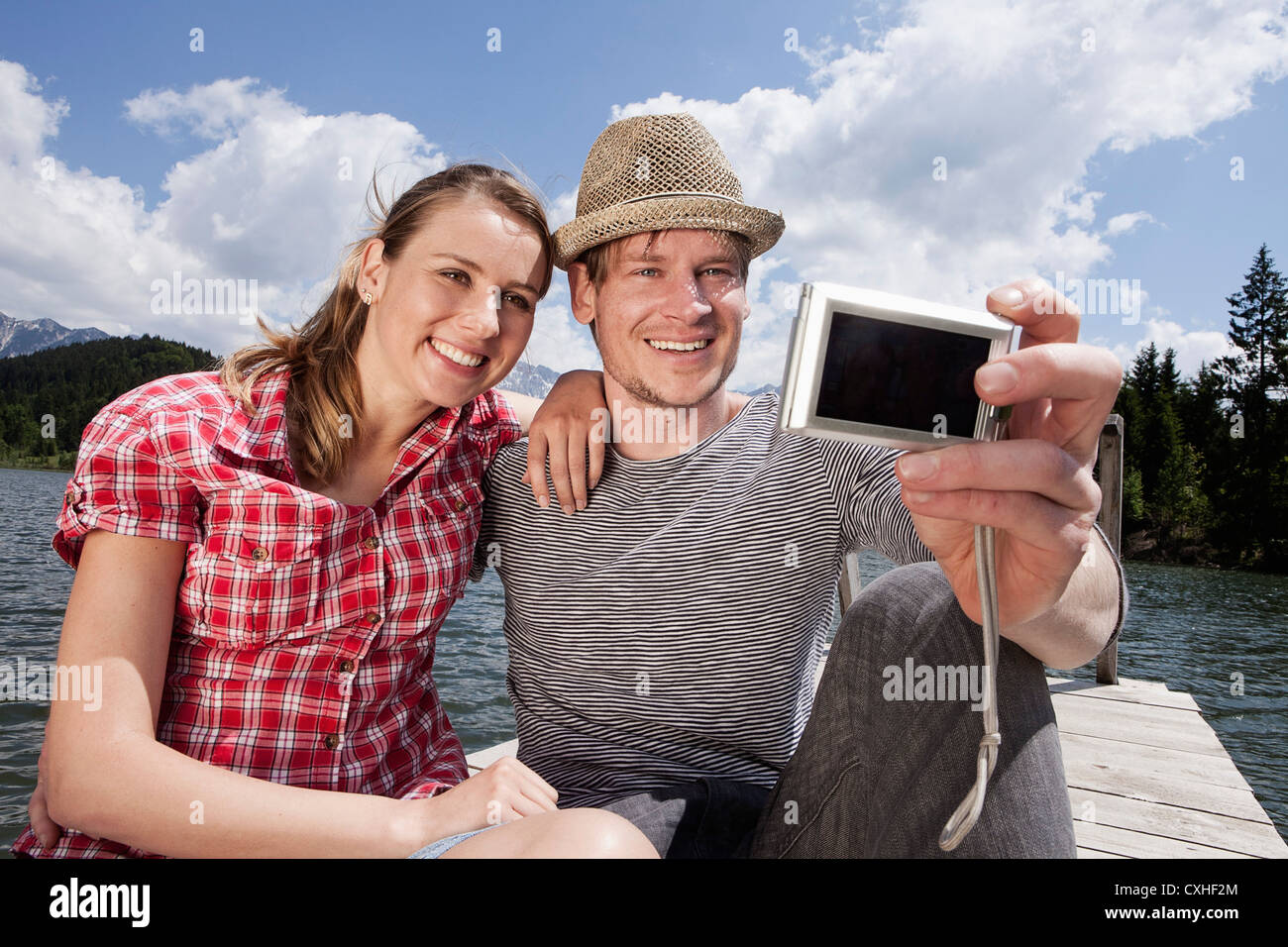 Germany, Bavaria, Couple taking self photo, smiling Banque D'Images