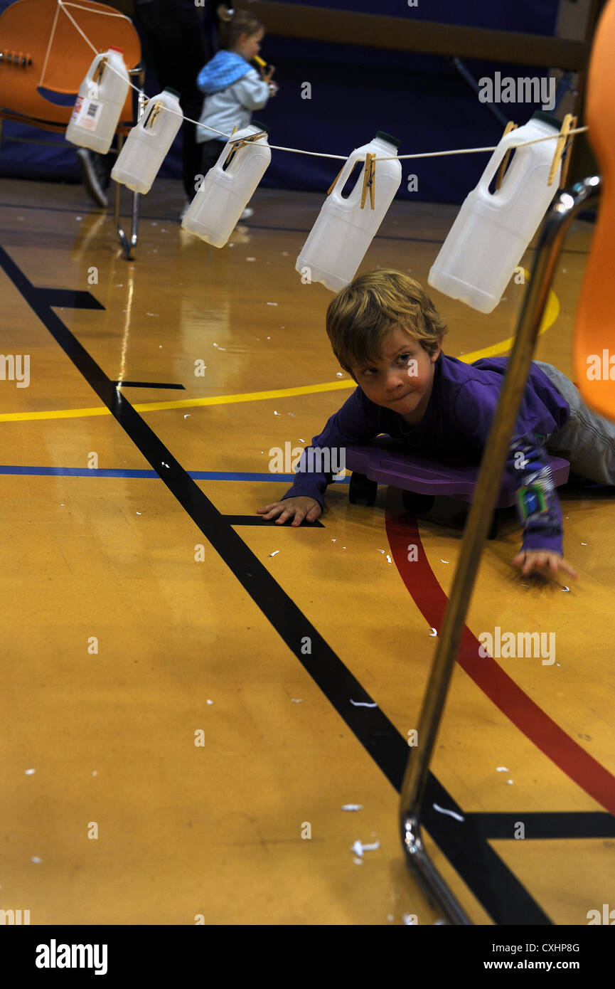 Michael Davis navigue sur un parcours d'obstacles à bord d'un scooter lors de la Journée mondiale du jeu au RAF Mildenhall Youth Center, qui présentait diverses activités récréatives pour la communauté. Banque D'Images