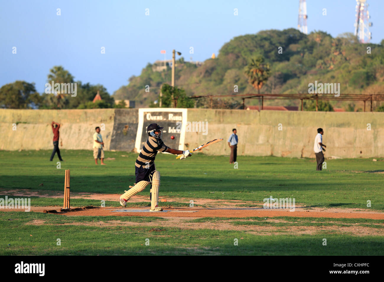 Les jeunes hommes jouant un jeu de cricket pratique à Trincomalee, Sri Lanka. Banque D'Images