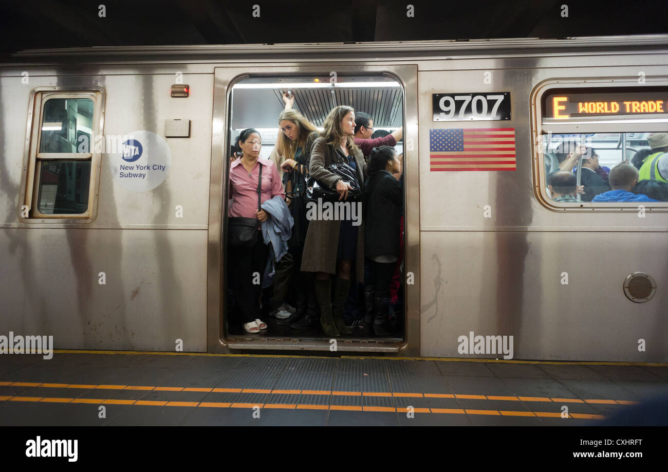 Les passagers s'entassent dans un panier-E train dans le métro de New York  dans les quartiers de Queens Photo Stock - Alamy