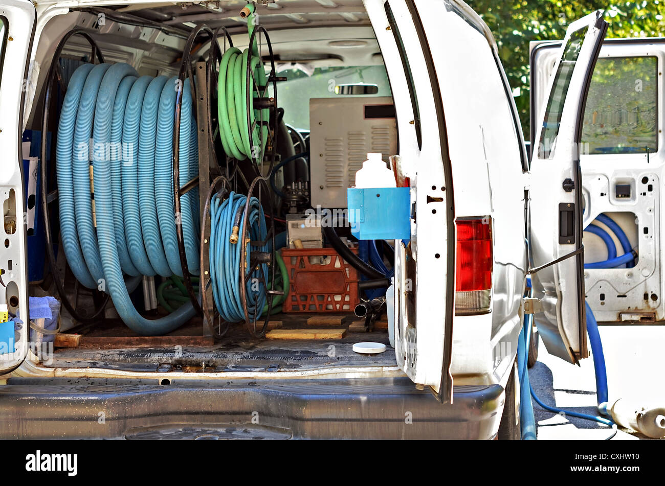 Une camionnette blanche avec flexibles et de l'équipement pour le nettoyage de tapis. Banque D'Images