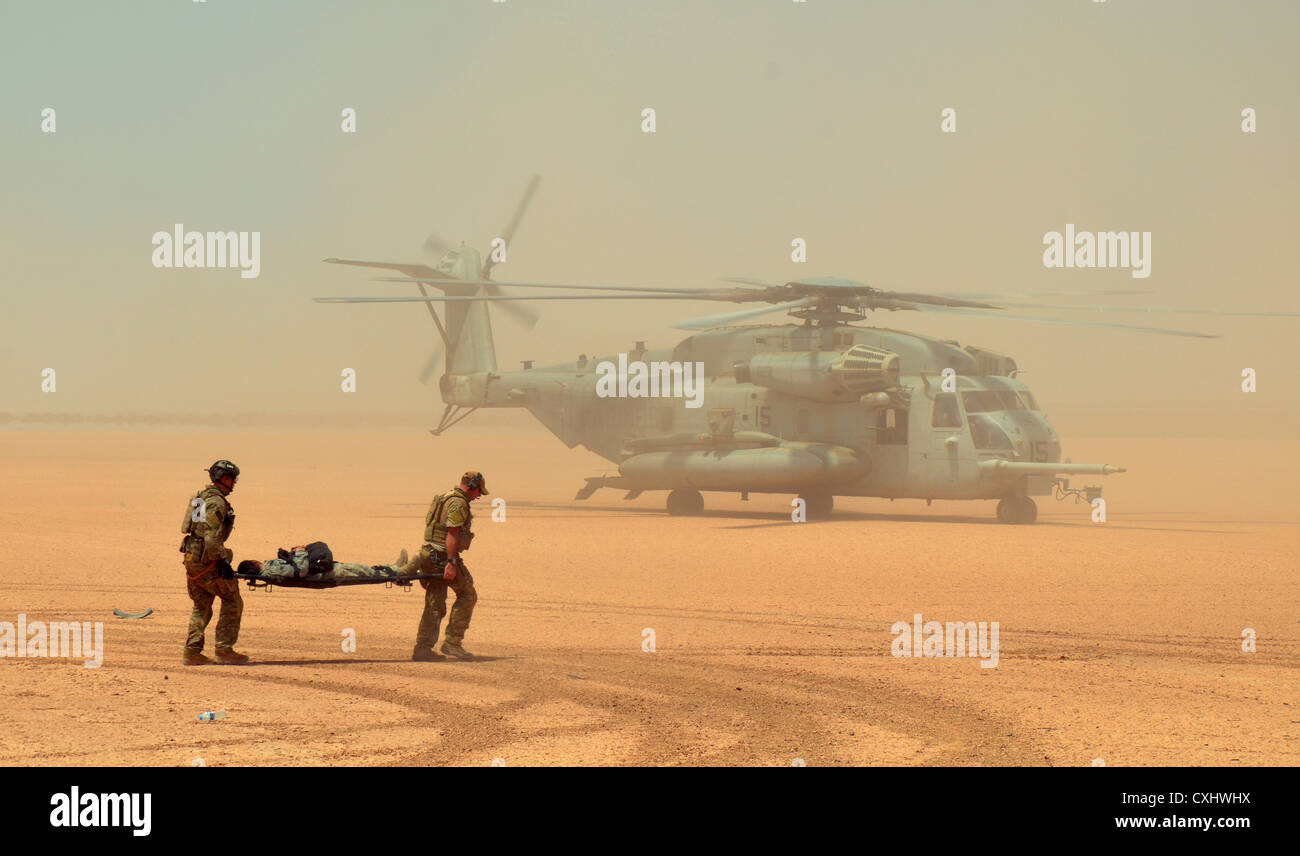 Air Force para-sauvetage d'aviateurs rush d'un exercice de simulation de blessures participant avec une Marine Corps CH-53E Super Stallion helicopter le 25 septembre 2012 à Grand Bara Desert, à Djibouti. Banque D'Images