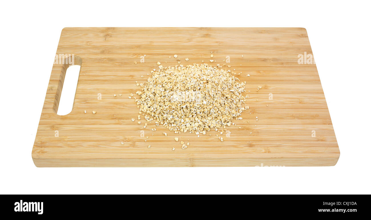 Une petite partie de l'avoine sur une coupe en acier planche à découper en bois. Banque D'Images