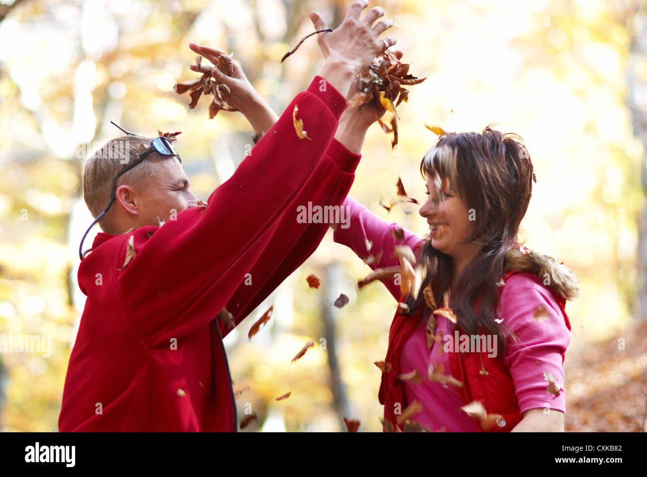 Jeune couple appréciant les feuilles qui tombent Banque D'Images