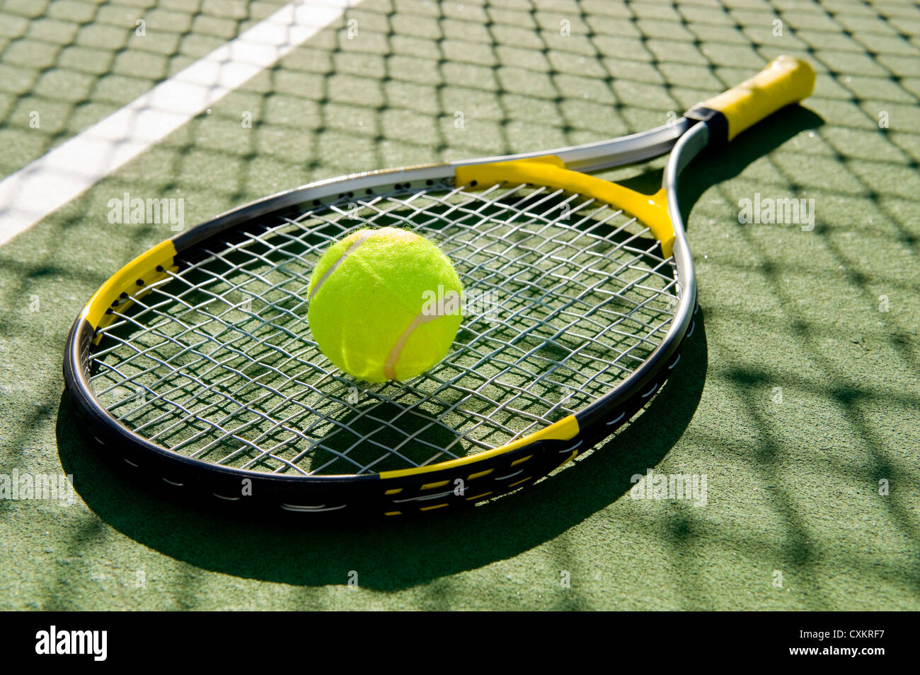 Une raquette de tennis et nouvelle balle de tennis sur un court de tennis récemment peintes Banque D'Images