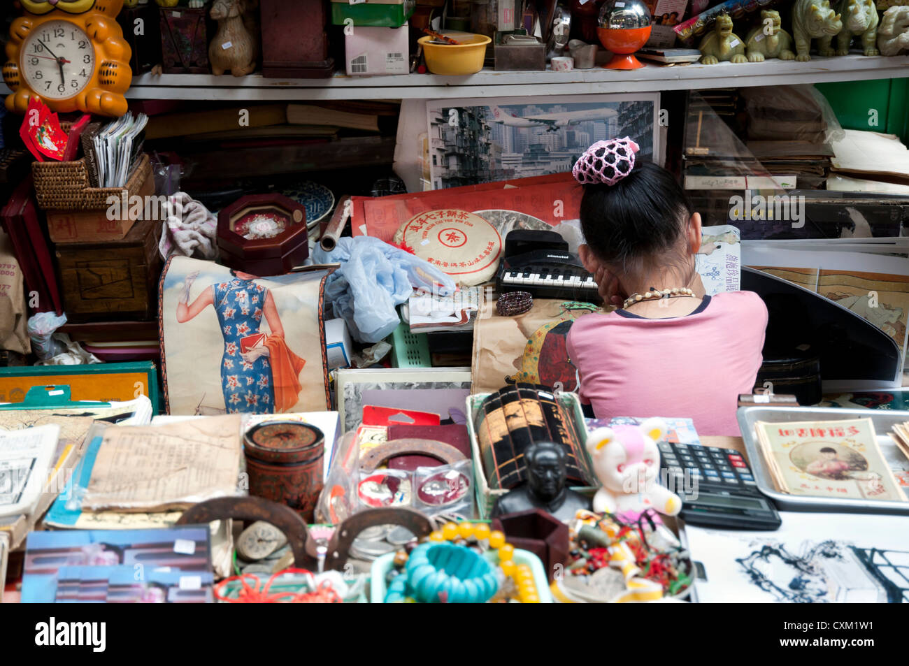 Jeune fille à un décrochage d'antiquités à cat street market, hong kong Banque D'Images