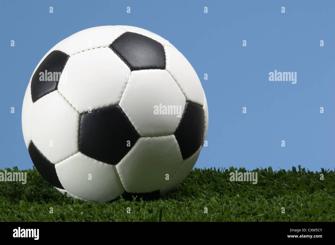 Football, ballon de football sur herbe avec ciel bleu Banque D'Images