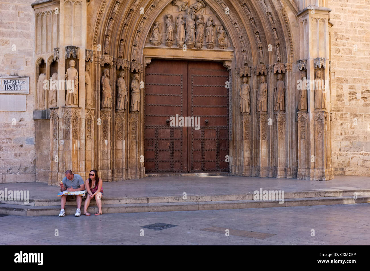 Valencia, Espagne : les touristes de prendre un certain temps pour étudier une carte et guide de voyage sur les marches de la cathédrale Banque D'Images