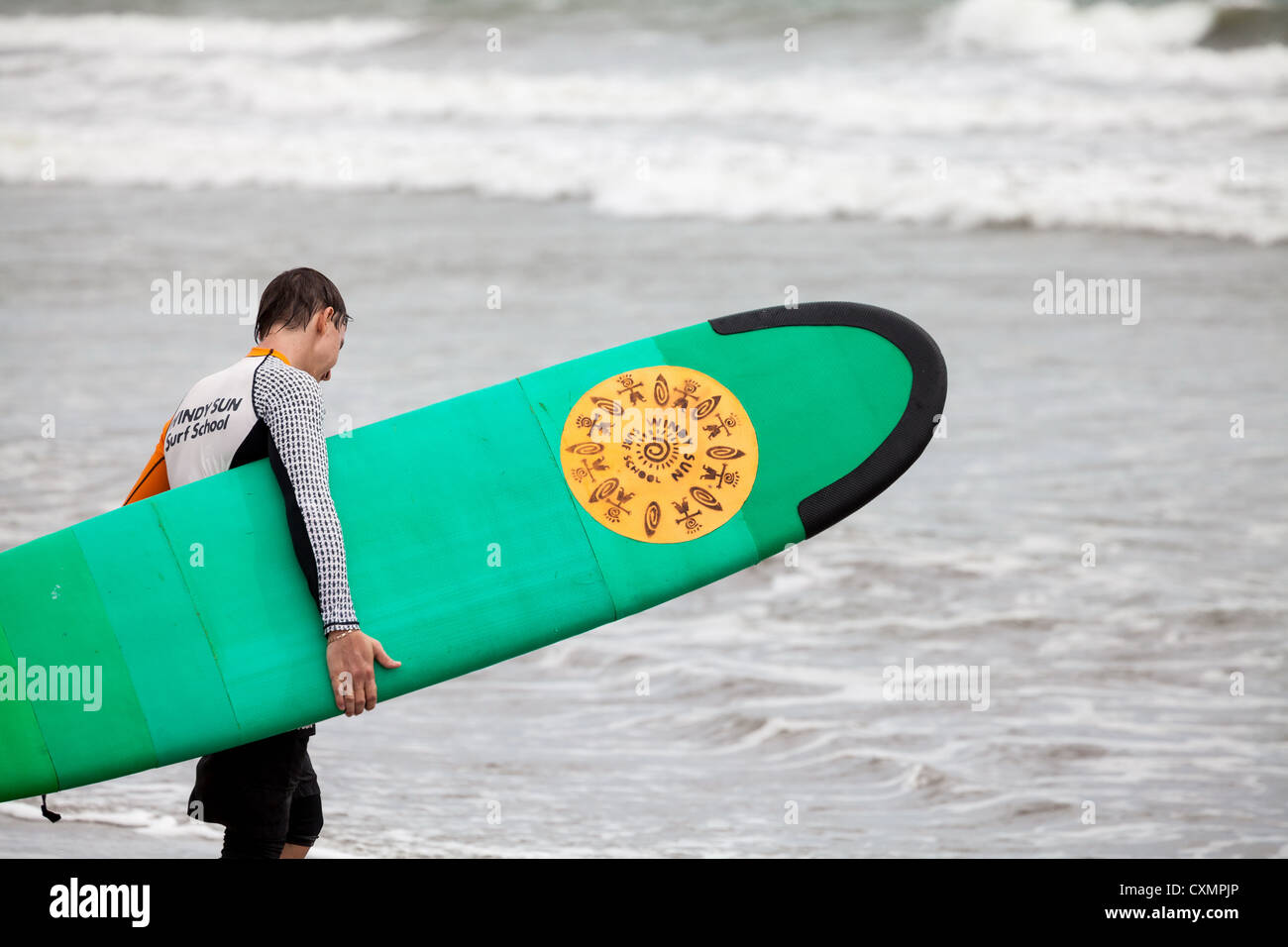 Surfer sur la plage de Kuta à Bali Banque D'Images