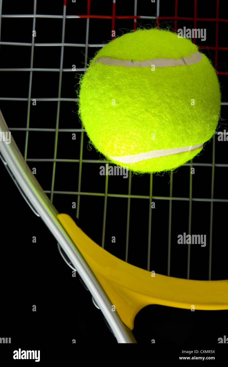 Raquette et balle de tennis sur fond noir Banque D'Images