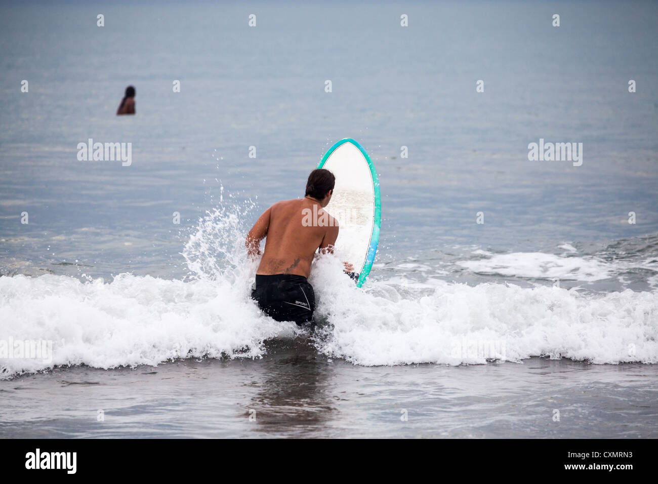 Surfer sur la plage de Kuta à Bali Banque D'Images