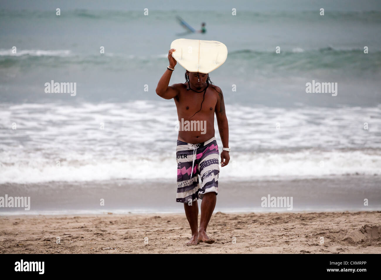Surfer sur la plage de Kuta à Bali Banque D'Images